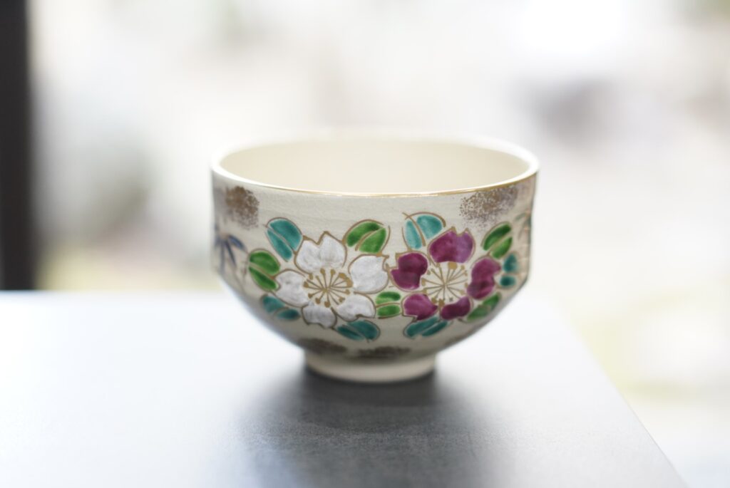 Close-up of a floral-patterned Kyoto tea bowl (chawan) on a table at the TIA tea ceremony experience.